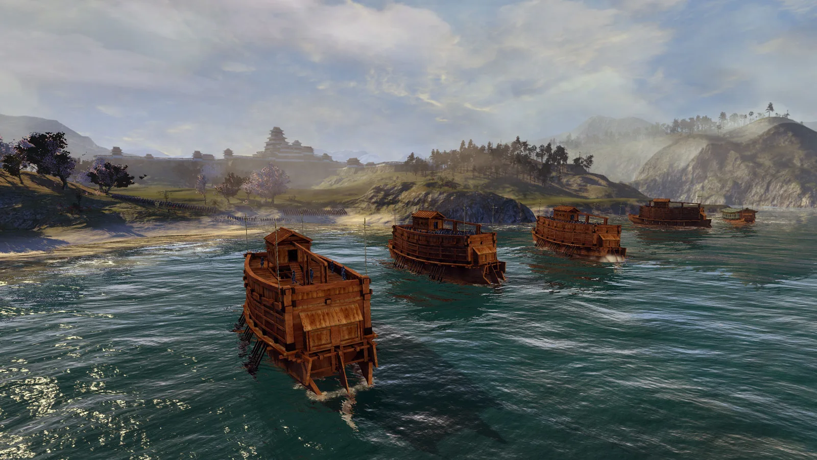 A classic Shogun 2 fleet sailing near the Japanese coast, illustrating sea approaches that can threaten ports during a wider war.