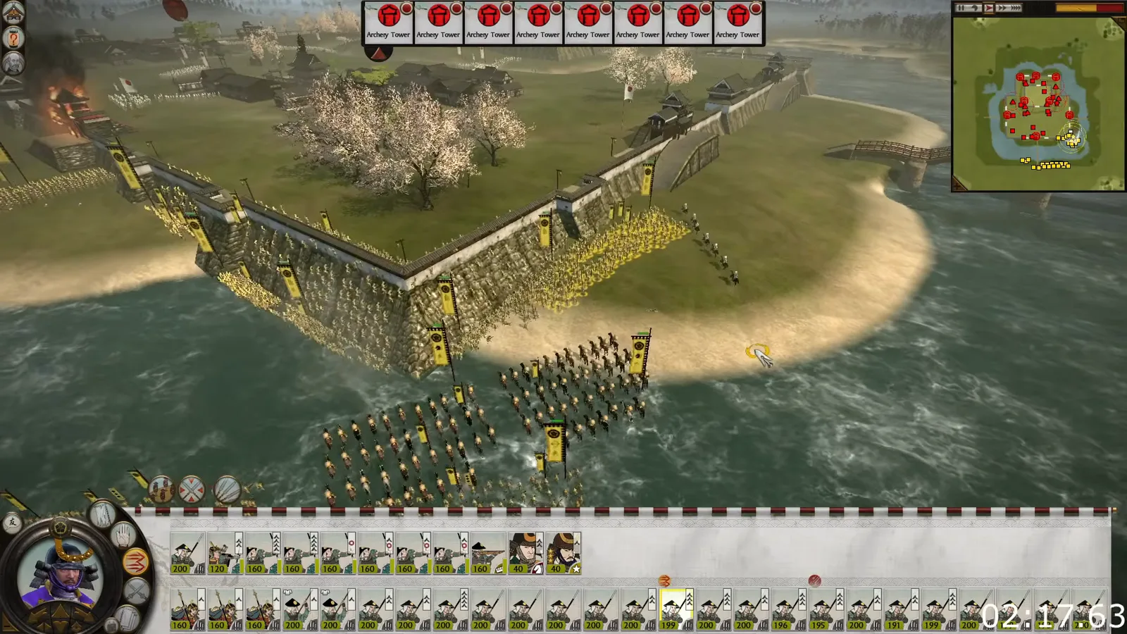 Yellow-bannered infantry scale the outer wall of a multi-tier Shogun 2 castle while supporting troops approach from the water.