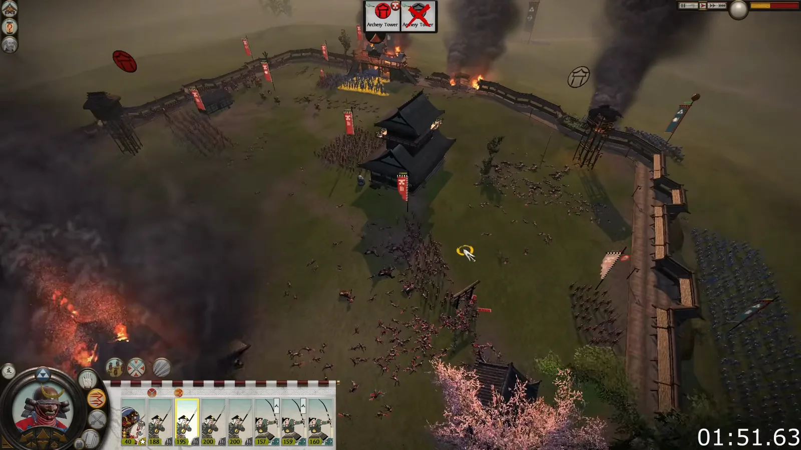 A classic Shogun 2 single-tier castle courtyard contains troops around the central keep and burning defensive towers.